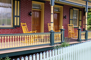 Colorful brick faced front porch and rocking chairs