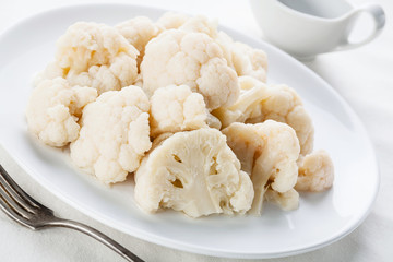 Steamed cauliflower with sauce on white plate