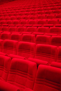 Rows of red arm-chairs in empty hall