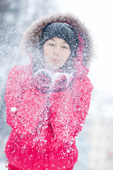 Happy young woman plays with a snow