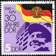 stamp printed by Germany, shows DDR Arms and Flag Worker