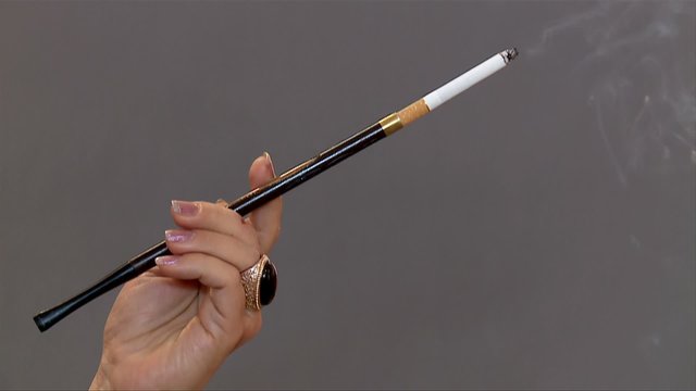 Woman's hand with cigarette in mouthpiece