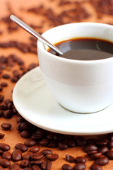 Cup of coffee with coffee beans and spoon