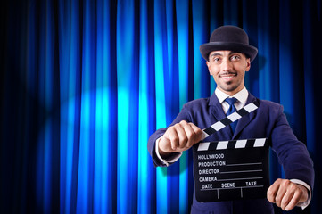Man with movie clapper on curtain background