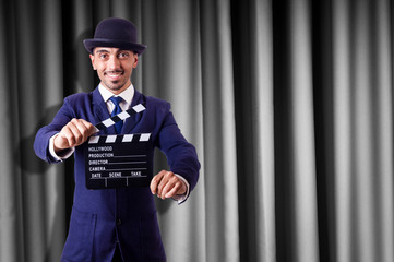 Man with movie clapper on curtain background