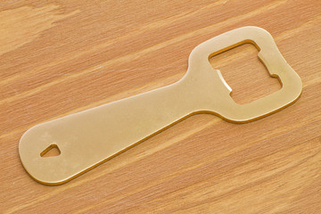 Golden bottle opener on wooden table
