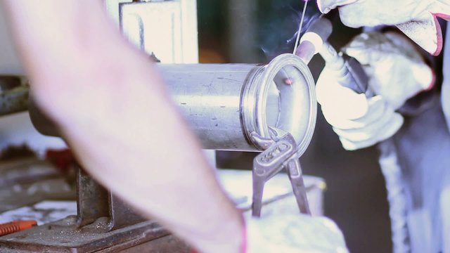 operai mentre saldano un tubo