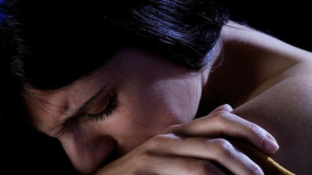 Scared woman crying sad in the dark
