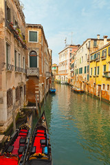 Venetian canals with houses and two gondola boats. Venice. Italy