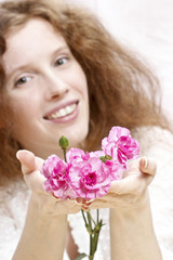 Young beautiful girl holding pink carnation flowers.