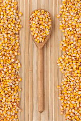 Wooden spoon with corn lying