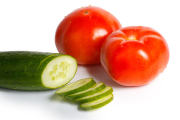 Tomatoes and sliced cucumber on a white background