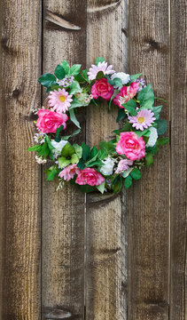 Floral wreath hanging on rustic wooden fence
