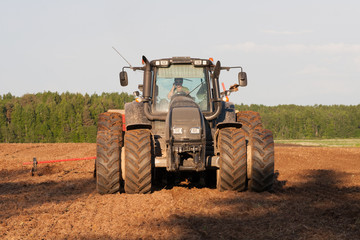 Obraz premium Big wheeled modern tractor in field