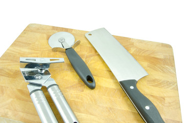 tin opener, pizza wheel and cleaver on board