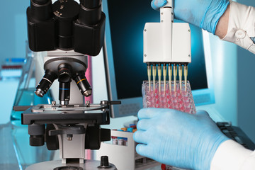 scientist pipetting a plate pink