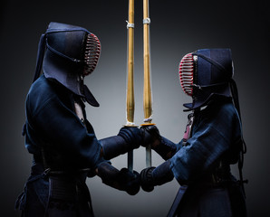 Two kendo fighters with shinai opposite each other