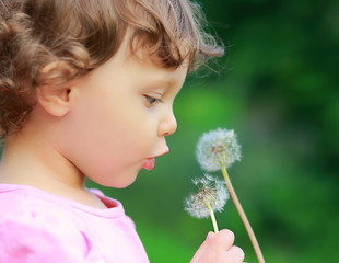 Fun girl looking on flower on summer day. Closeup portrait