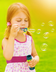 Baby girl blowing soap bubbles