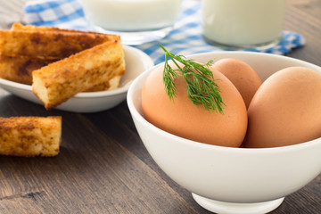 Eggs and milk on wooden background