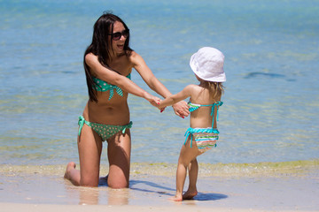 Mother and her little daughter at tropical beach