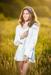 Vintage looking pose of a Young woman standing in a wheat field