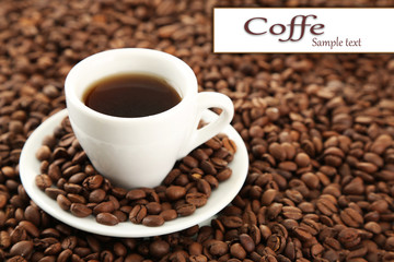 Cup of coffee on coffee beans close-up background