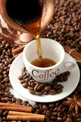 Cup and pot of coffee on coffee beans background