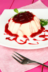 Panna Cotta with raspberry sauce, on color wooden background