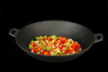 Vegetable ragout in wok, isolated on black