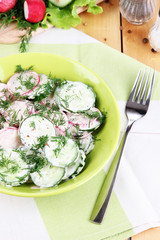 Fototapeta na wymiar Vitamin vegetable salad in bowl on wooden table close-up