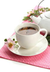 Cup and teapot of herbal tea with hip rose flowers, isolated