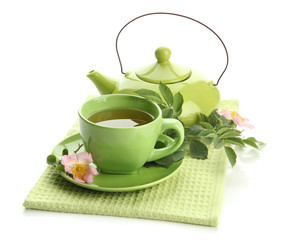 Cup and teapot of herbal tea with hip rose flowers, isolated