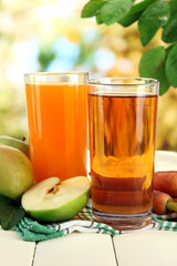 Glasses of juice, apples and carrots