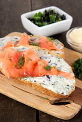 Fish sandwiches on cutting board on wooden table
