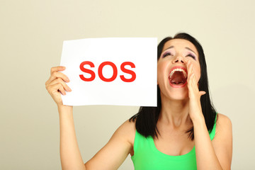 Girl showing stop sign on grey background