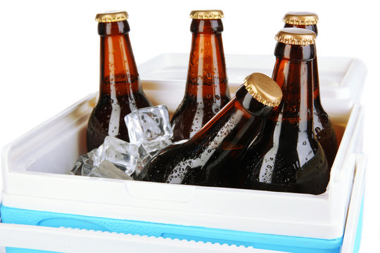 Traveling refrigerator with beer bottles and ice cubes isolated
