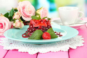 Tasty jelly dessert with fresh berries, on bright background