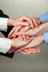 Group of young people's hands on gray background