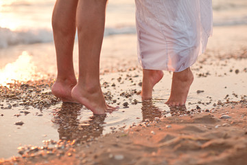Fototapeta na wymiar legs of kissing couple on beach