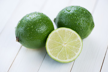 Two ripe limes and their segment, horizontal shot