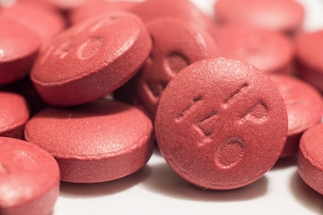 Obraz na płótnie Canvas Macro shot of red pills on white
