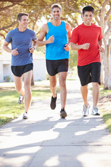 Group Of Male Runners Exercising On Suburban Street
