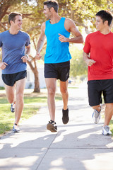 Group Of Male Runners Exercising On Suburban Street