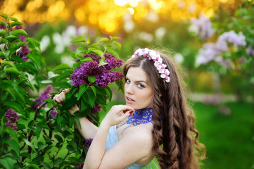 beautiful girl with a flower lilac the sun