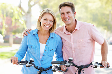 Obraz premium Couple Cycling On Suburban Street