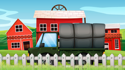 A green cargo in front of a barn inside the fence