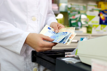 Money euros hold by pharmacist at counter