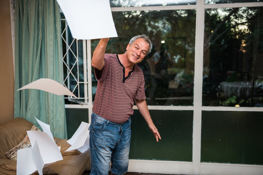 Senior Man Throwing  Clear White Papers In The Air