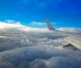 Aircraft wing flying onver a sea of clouds